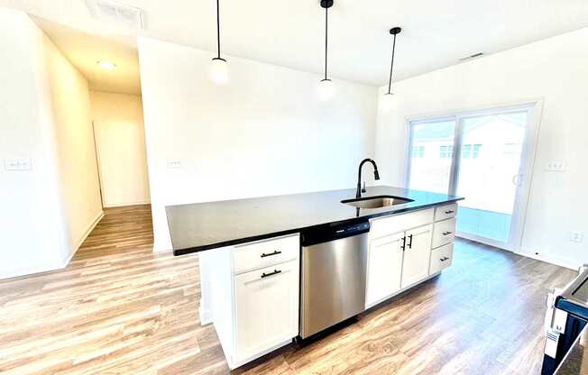 A kitchen with a black counter top and white cabinets.