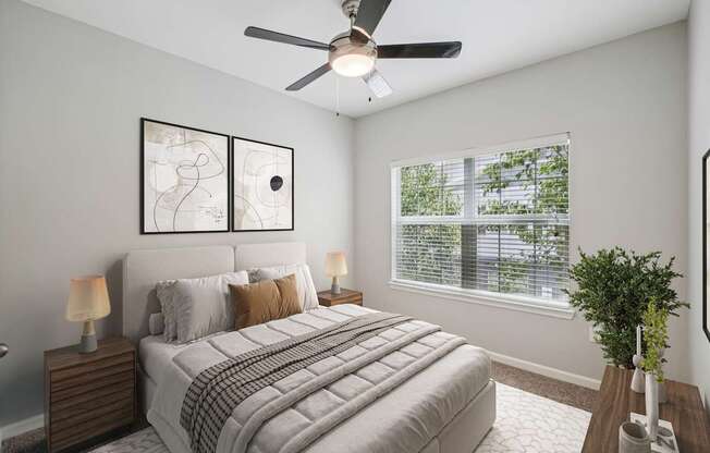 A bedroom with a bed, two lamps, a ceiling fan, and a window with blinds.