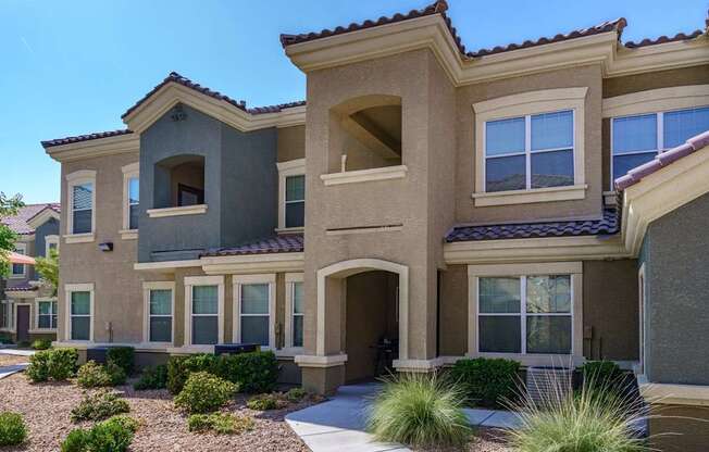 A modern house with a grey roof and tan walls.