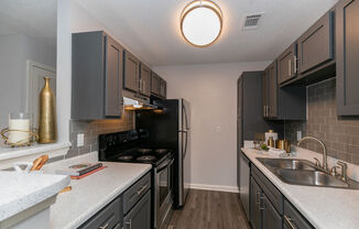 a kitchen with black appliances and white counter tops