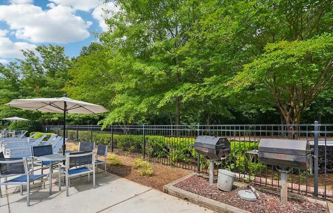 A grill area with a table and chairs.
