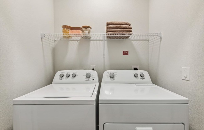 two washers and a dryer in a laundry room
