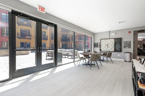 a communal area with a table and chairs and a large screen tv on the wall