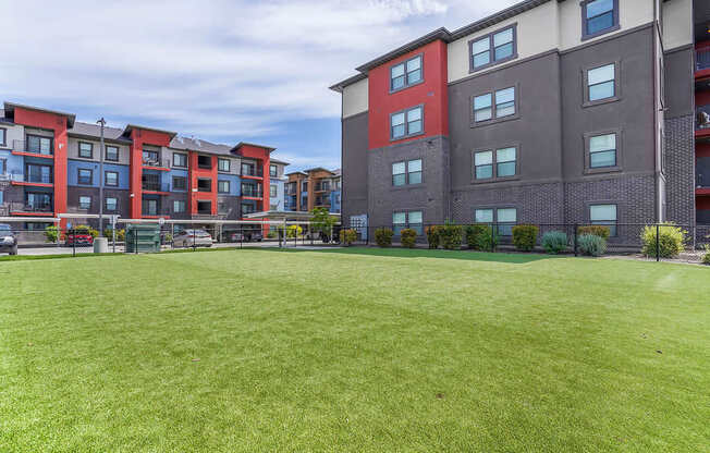 A grassy area in front of apartment buildings.