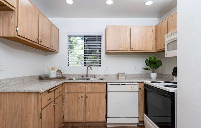 A kitchen with wooden cabinets and a white dishwasher.