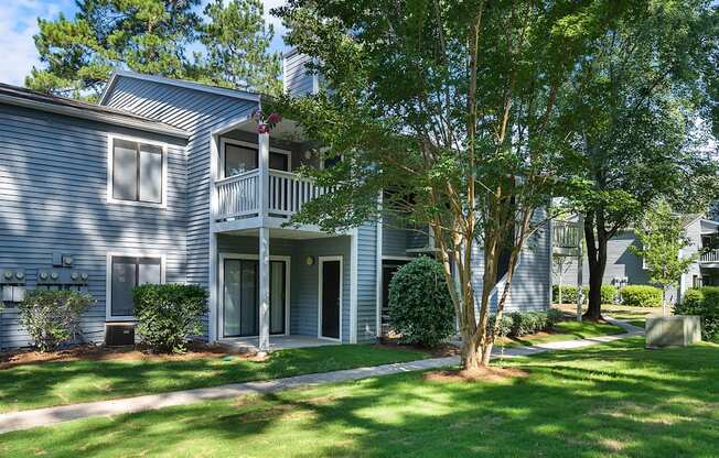 A house with a grey siding and a white porch.
