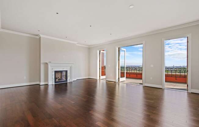 an empty living room with a fireplace and wooden floors