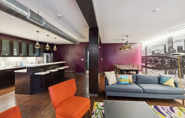 A living room with a couch, chair, and a kitchen area.
