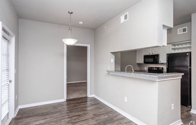 an empty apartment with a kitchen and a door to the living room
