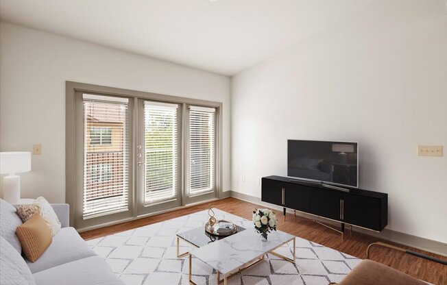 a living room with white walls and hardwood floors