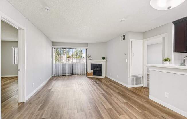 A spacious living room with hardwood floors and a fireplace.