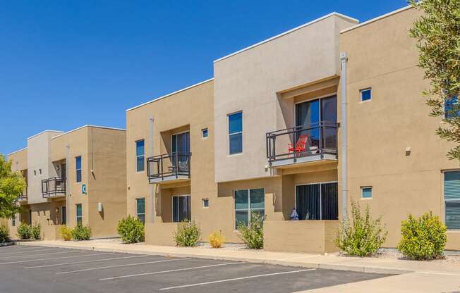 a row of apartments with balconies and a parking lot
