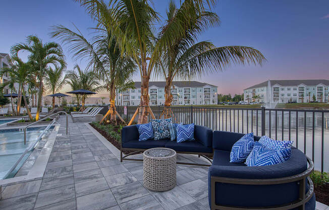 A patio with a couch and a pool.