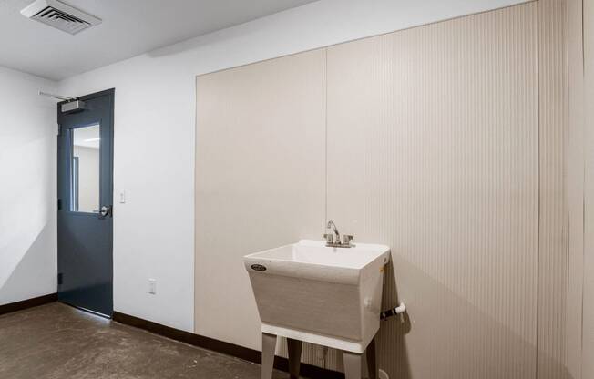 a sink in a bathroom with a blue door in the background at The Flats at Riverwoods, Provo, Utah