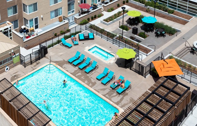 an overhead view of a swimming pool at a hotel with chairs and umbrellas