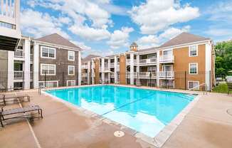 A large swimming pool in front of apartment buildings.