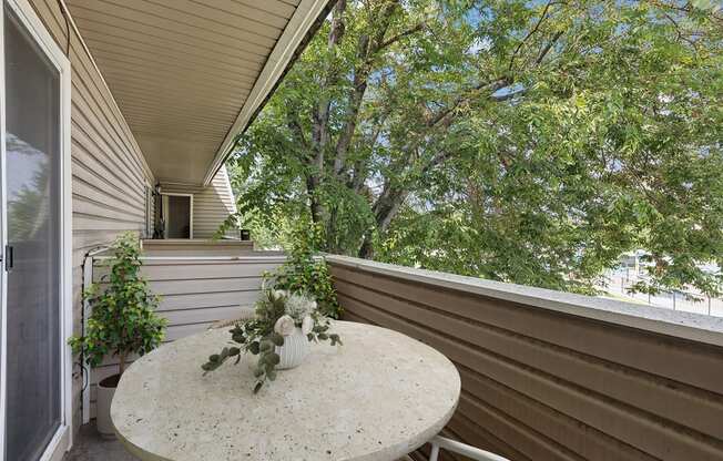 a patio with a table and a vase of flowers on it