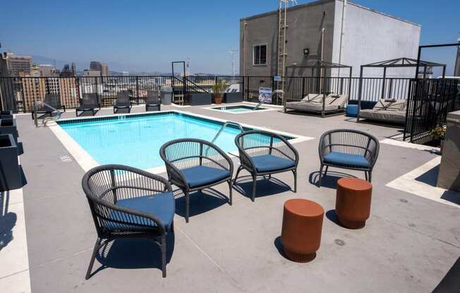 the pool at the top of a building with chairs