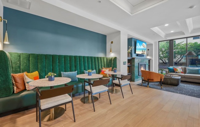 a lounge area with tables and chairs and a green couch