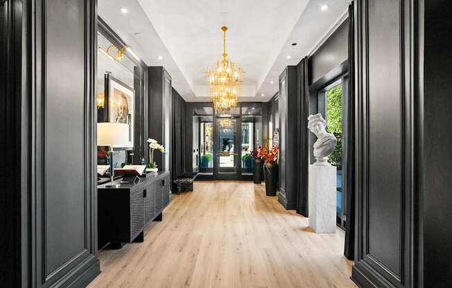 A long hallway with a chandelier hanging from the ceiling.