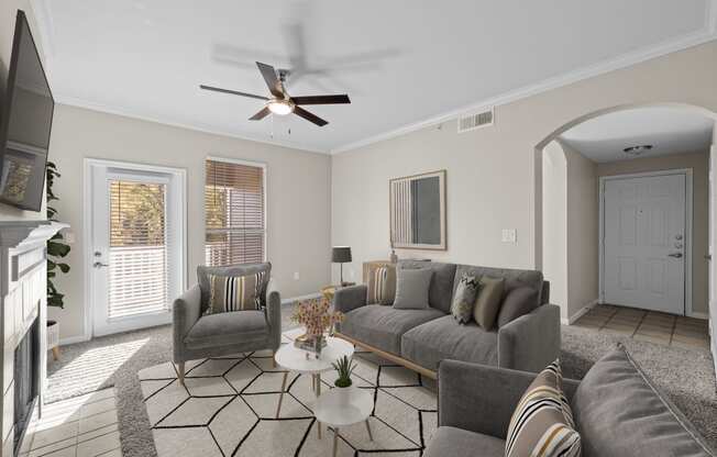 a living room with couches and chairs and a ceiling fan