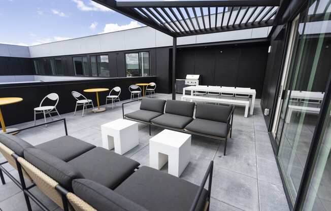 a patio with couches and tables on a balcony at Analog PDX Apartments, Portland