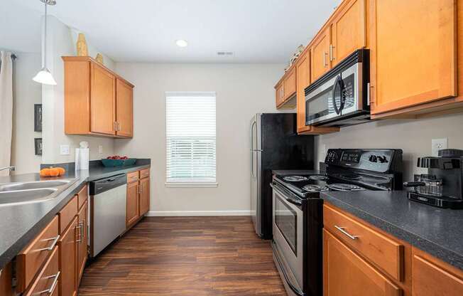 A kitchen with wooden cabinets and black appliances.