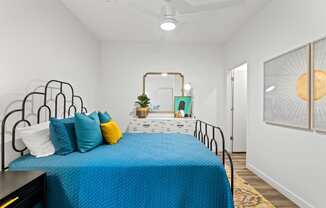 a bedroom with a bed with blue sheets and pillows