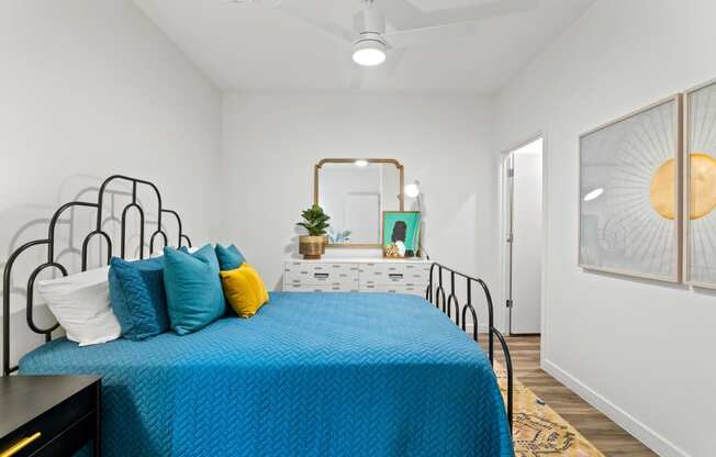 a bedroom with a bed with blue sheets and pillows