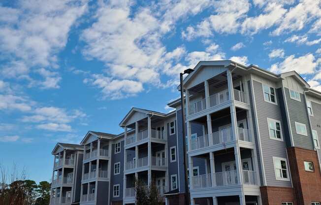 a row of apartment buildings with a blue sky in the background