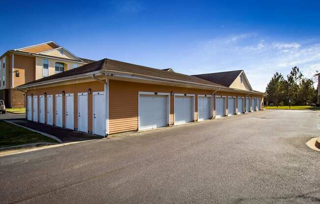 a row of garages with white doors in front of a house