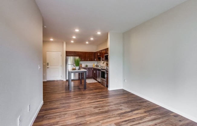 a kitchen and living room with hardwood floors and white walls