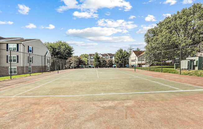 A tennis court surrounded by houses and trees.
