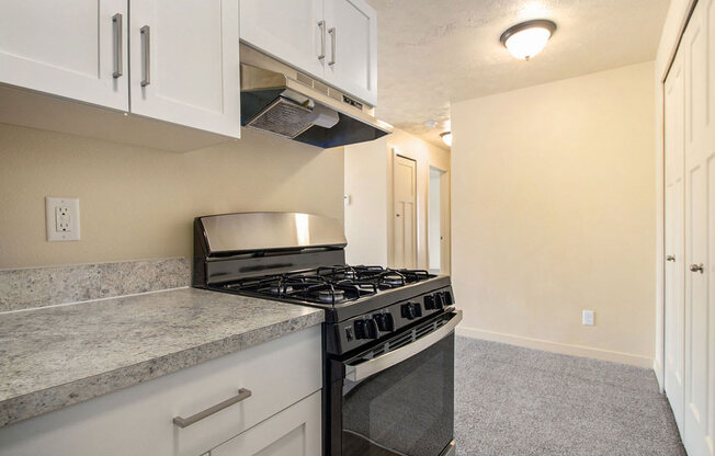 a kitchen with a gas stove and white cabinets at Old Farm Apartments, Elkhart, Indiana