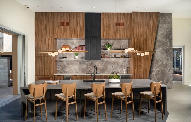 a kitchen with wooden cabinets and a long island with chairs and a sink