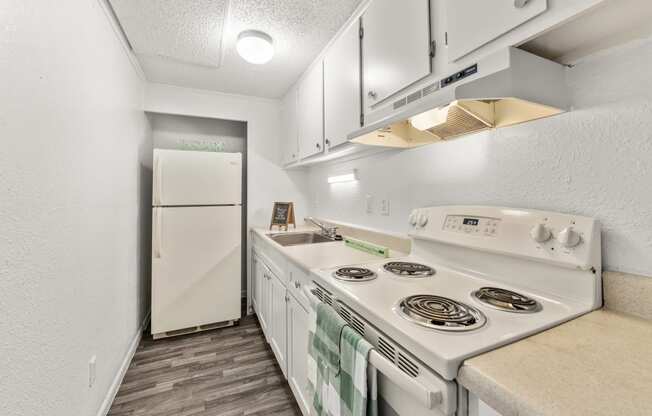 a kitchen with white appliances and a white refrigerator