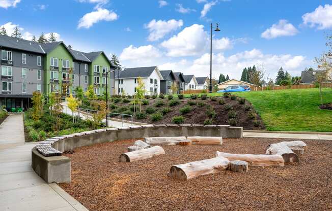 a playground with logs and houses in the background