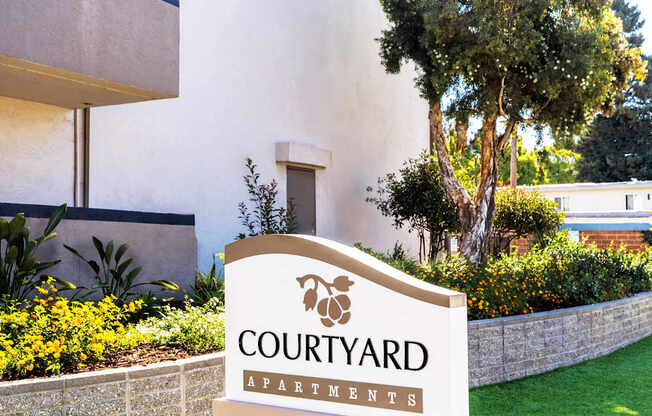 A sign for Courtyard Apartments is in front of a building.