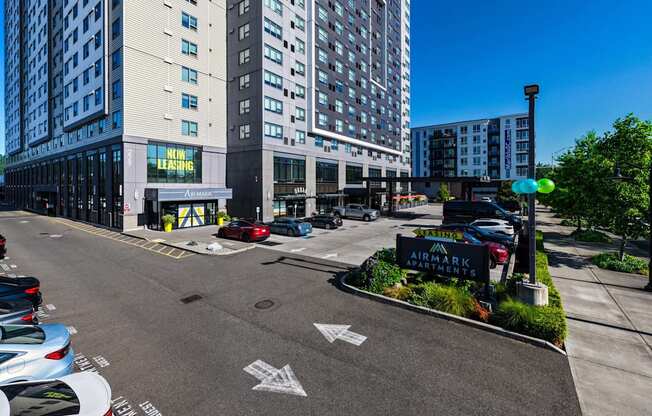 A view of a parking lot with cars and a building with a sign that reads