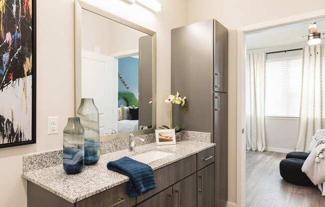 Modern bathroom with granite and ample cabinetry at Residences at The Green in Lakewood Ranch, FL