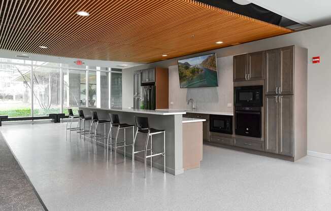 A modern kitchen with a long island and stainless steel appliances.