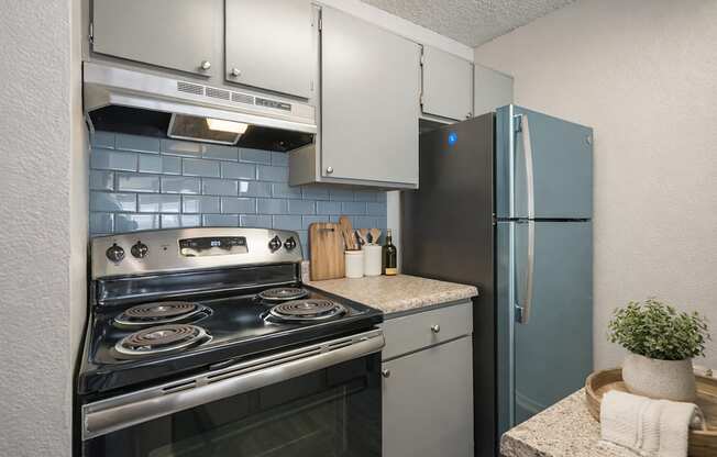 A kitchen with a stove, oven, and refrigerator.