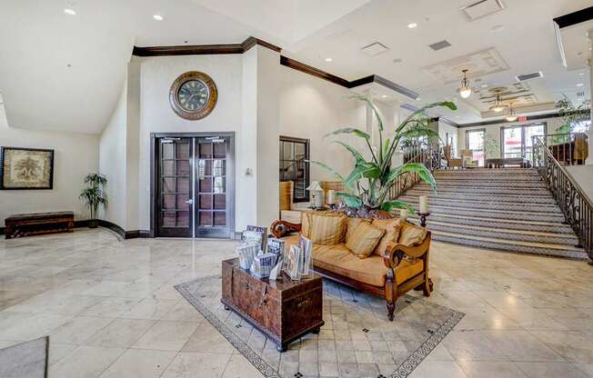 A living room with a couch, a coffee table, and a staircase.