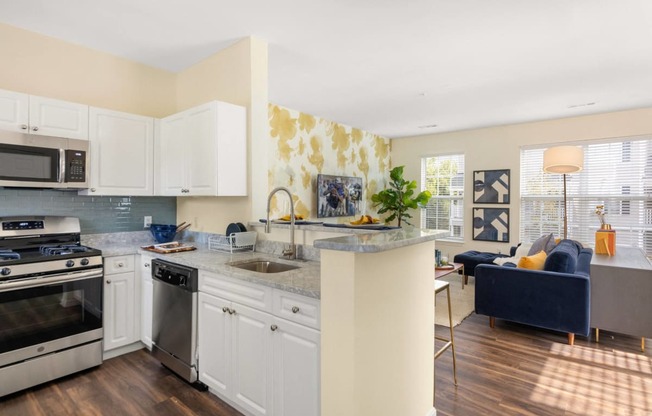 a kitchen with an island and a living room with a couch at Residences at Stevens Pond, Saugus, 01906