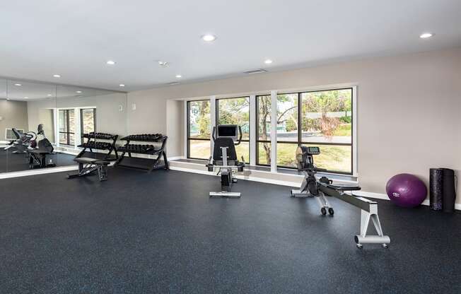 a gym with exercise equipment and windows in a building