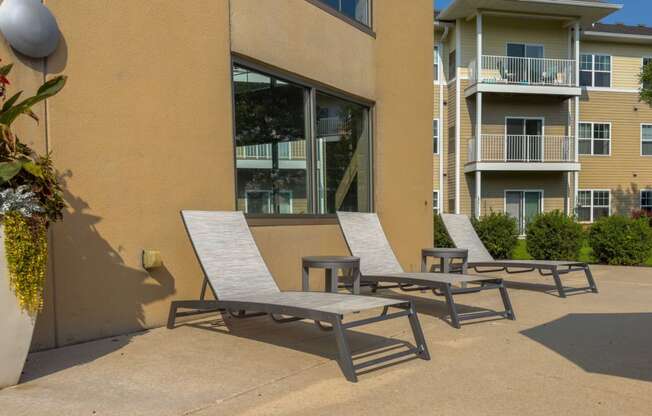 a patio with two chairs and a table in front of a building