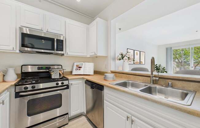 A kitchen with white cabinets and stainless steel appliances.