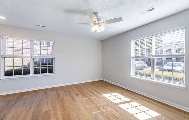 A room with a ceiling fan and wooden flooring.