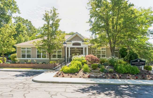 the front of a house with a driveway and trees