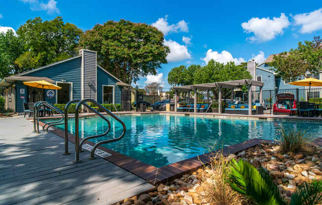 a swimming pool with a house and trees in the background